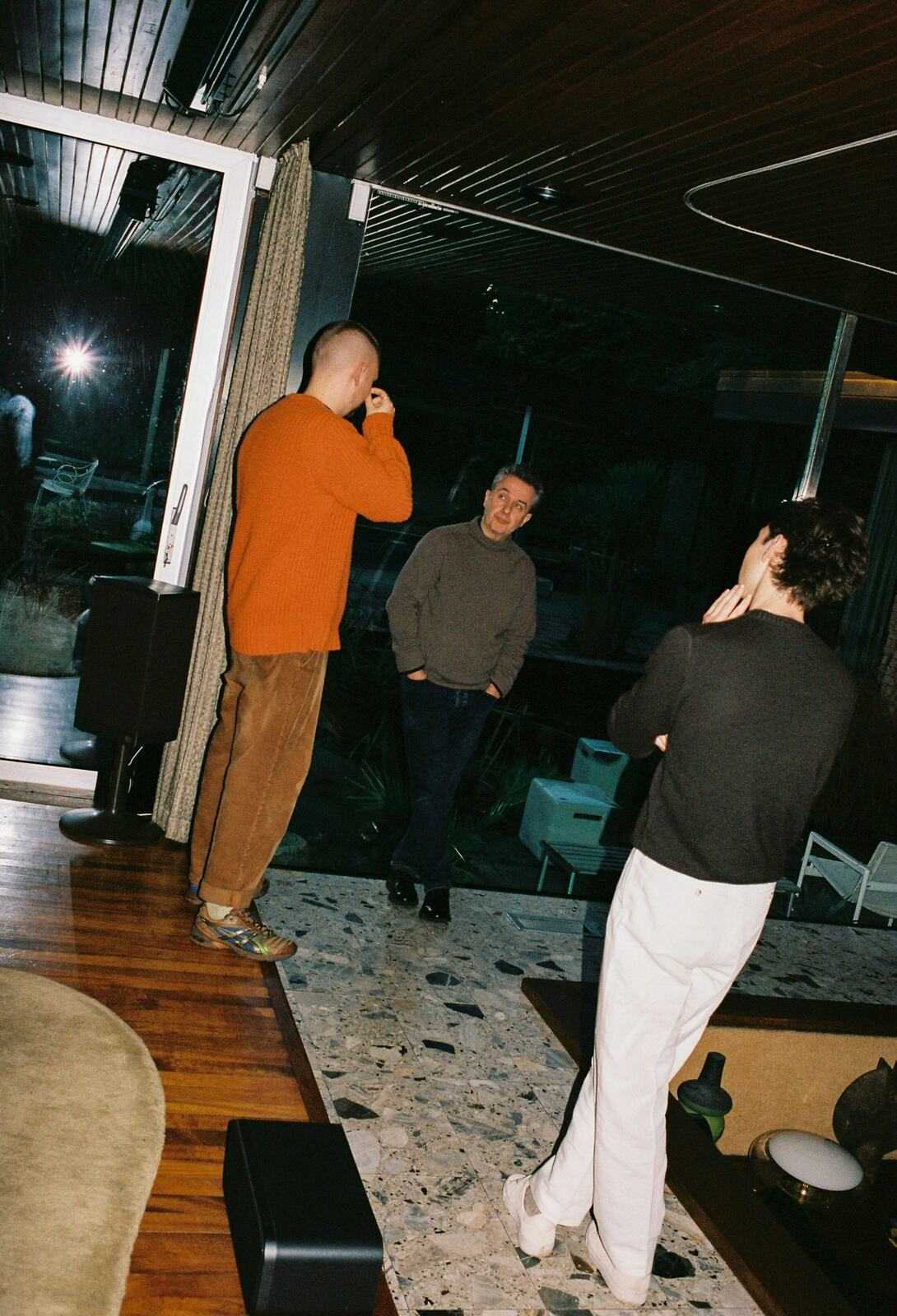 The FolkTale founders talking with a client inside a mid-century house at night